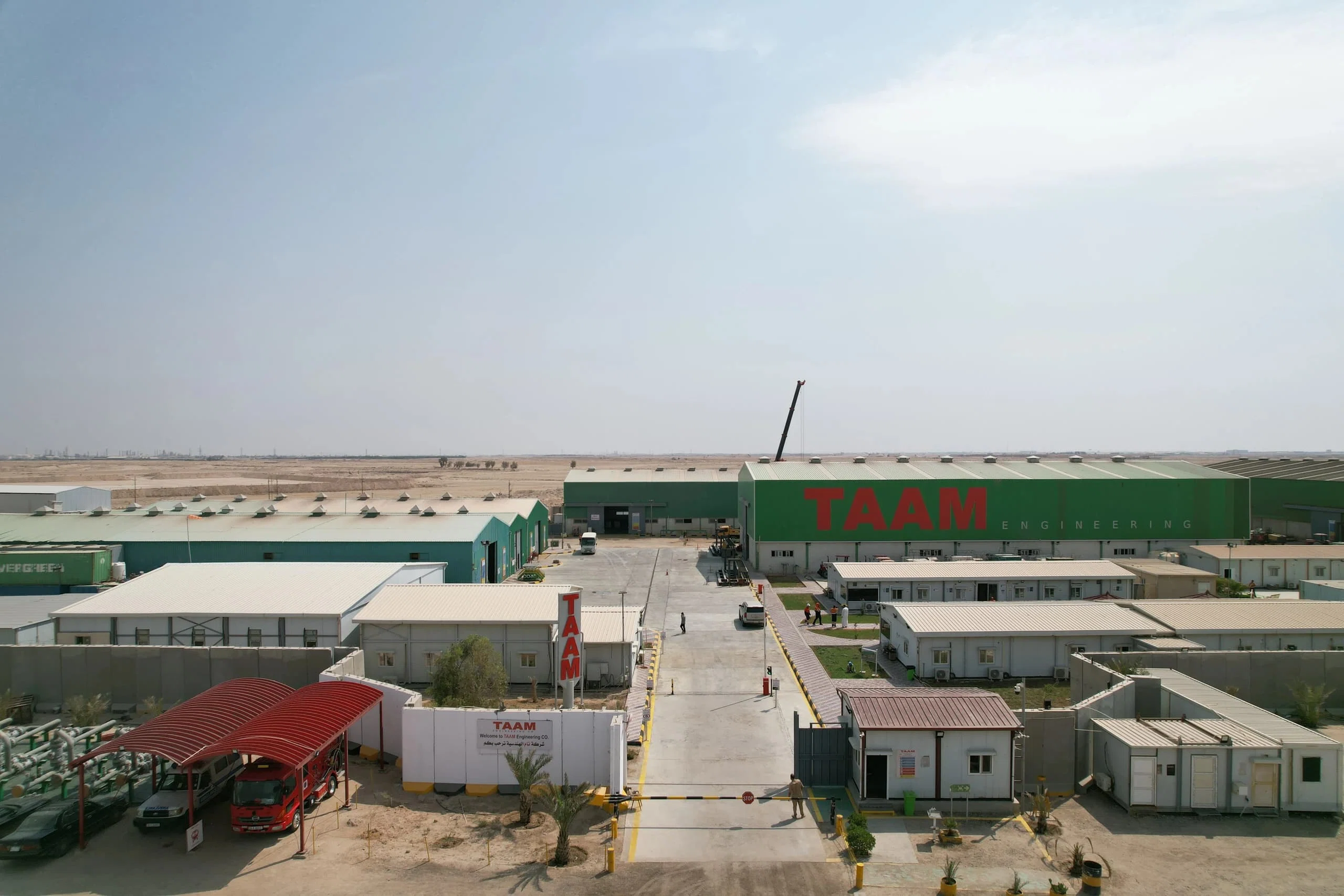 TAAM main camp with the red TAAM sign on the green workshop building